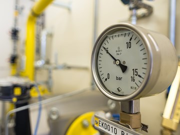 Manometer an einer Anlage mit gelben Rohren zeigt knapp fünf Bar an Manometer an einer Anlage mit gelben Rohren zeigt knapp fünf Bar an