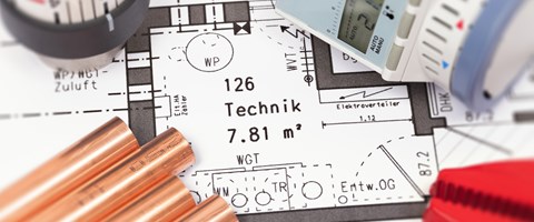 Nahaufnahme einer Bauzeichnung, auf dem Plan liegen Heizungsteile Nahaufnahme einer Bauzeichnung, auf dem Plan liegen Heizungsteile