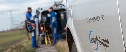 Mitarbeiter an einem Technikfahrzeug auf einem Feldweg Mitarbeiter an einem Technikfahrzeug auf einem Feldweg