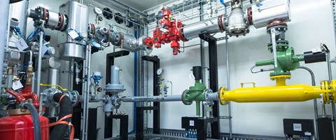 Raum mit Leitungen, Rohren und Messanzeigen Raum mit Leitungen, Rohren und Messanzeigen