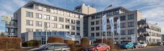 enviaM Firmengebäude mit Flaggen am Eingang in Kabelsketal - Außenaufnahme bei blauem Himmel enviaM Firmengebäude mit Flaggen am Eingang in Kabelsketal - Außenaufnahme bei blauem Himmel