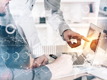 Zwei Männer im Büro vor einem Laptop, der eine deutet auf den Bildschirm - Bildmontage mit Grafiksymbolen Zwei Männer im Büro vor einem Laptop, der eine deutet auf den Bildschirm - Bildmontage mit Grafiksymbolen