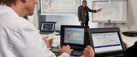 Mitarbeiter bei einer Präsentation von Bauplänen Mitarbeiter bei einer Präsentation von Bauplänen