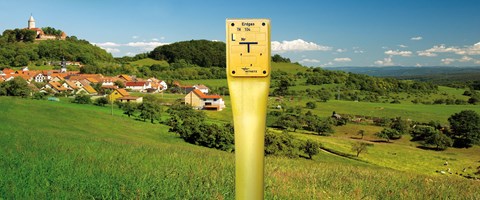 Erdgas-Schieber vor einer grünen, hügeligen Landschaft mit einer kleinen Stadt Erdgas-Schieber vor einer grünen, hügeligen Landschaft mit einer kleinen Stadt