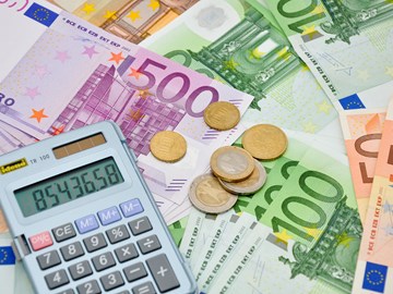 Taschenrechner und einige Münzen auf Eurobanknoten - Nahaufnahme Taschenrechner und einige Münzen auf Eurobanknoten - Nahaufnahme