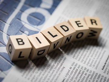 Sechs Holzwürfel auf einer Zeitung bilden das Wort „Bilder Sechs Holzwürfel auf einer Zeitung bilden das Wort „Bilder