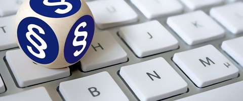 Ein Würfel, mit Paragrafenzeichen auf jeder Fläche, liegt auf einer Tastatur Ein Würfel, mit Paragrafenzeichen auf jeder Fläche, liegt auf einer Tastatur